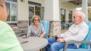 smiling residents enjoying clubhouse patio