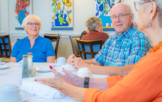 smiling residents in the dining room at buena vida estates